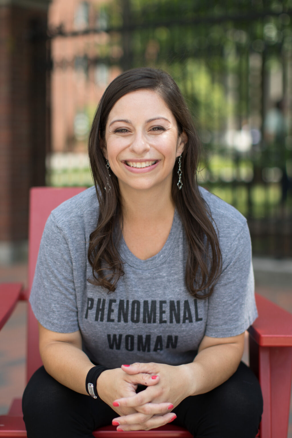 a woman sitting on a red bench smiling