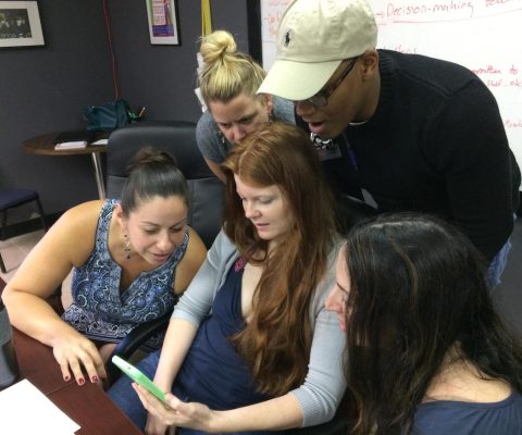 a group of young people looking at a computer screen