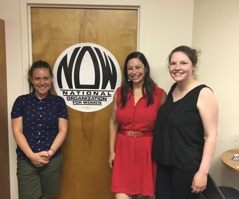 three women are standing in front of a door