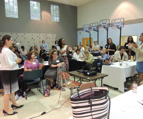 a room full of people sitting at tables