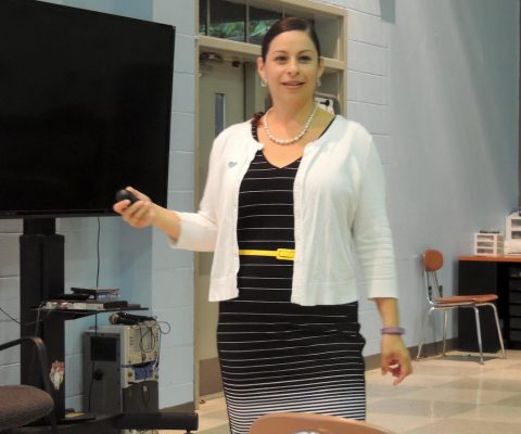 a woman standing in front of a tv holding a remote